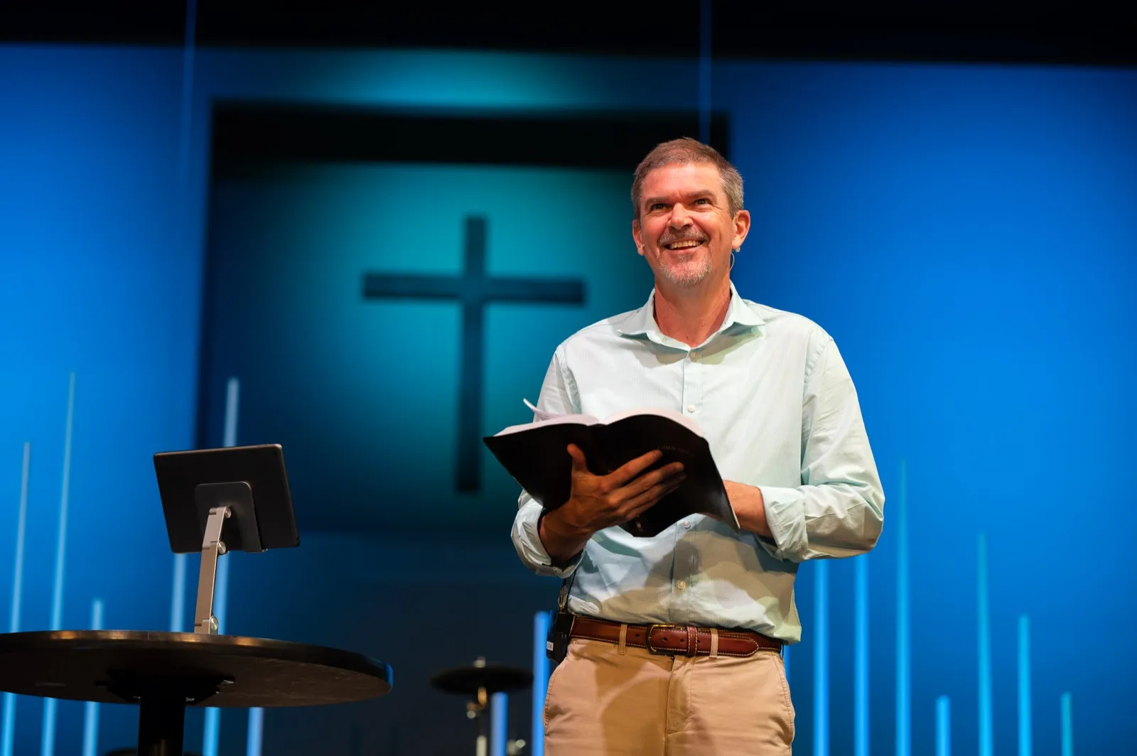 Lead Pastor Chris Stephens smiling with an open Bible while teaching