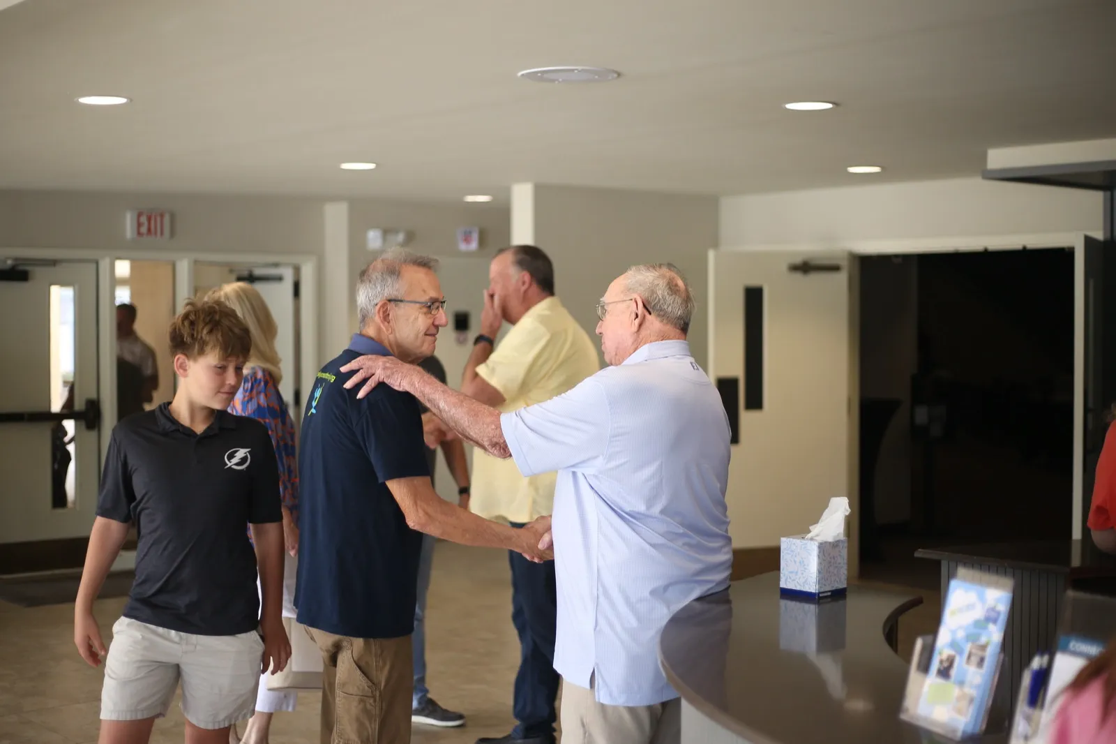 Two men greeting each other with a warm embrace in the lobby