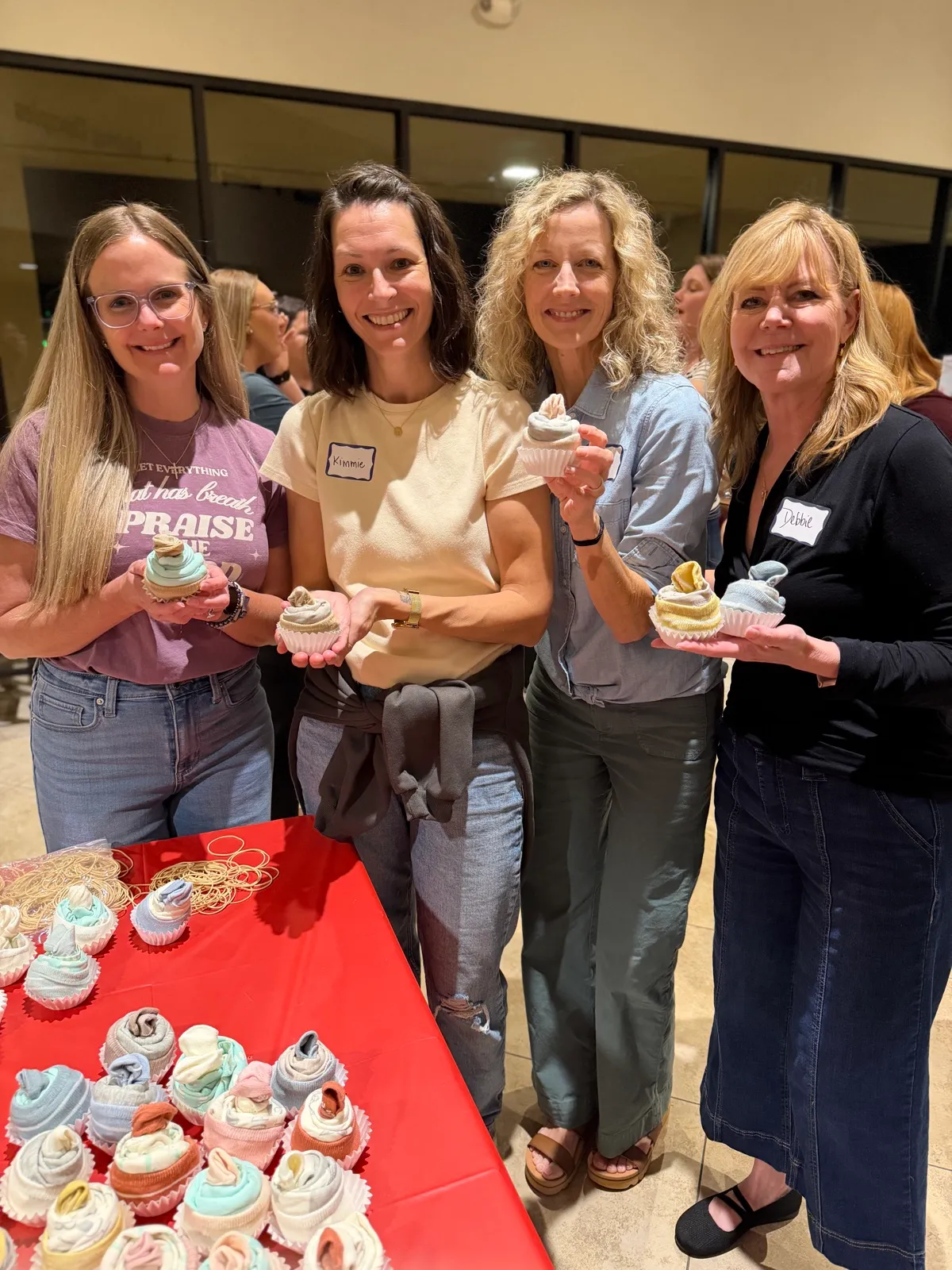 Four women laughing together at a church dessert event